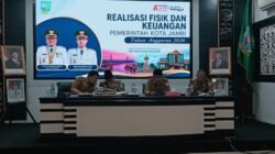 Maulana Memimpin  Rapat Evaluasi  Realisasi APBD OPD Tahun Anggaran 2026.   JAMBI – Memasuki semester kedua Tahun Anggaran 2026, Pemerintah Kota Jambi mulai menggenjot percepatan realisasi belanja daerah agar mampu menggerakkan perekonomian sekaligus memastikan seluruh program pembangunan selesai tepat waktu.  Langkah itu ditegaskan Wali Kota Jambi Maulana saat memimpin evaluasi realisasi APBD bersama seluruh kepala OPD dan camat di Aula Bappeda Kota Jambi, Senin (6/7).  Menurut Maulana, hingga awal Juli realisasi belanja daerah telah mendekati 50 persen, sedangkan pendapatan dari sektor pajak sudah mencapai sekitar 53 persen. Capaian tersebut dinilai masih sesuai dengan target, namun seluruh perangkat daerah diminta meningkatkan kecepatan pelaksanaan program agar manfaat APBD segera dirasakan masyarakat.  “Belanja pemerintah harus menjadi stimulus ekonomi. Karena itu saya minta seluruh OPD mempercepat pelaksanaan kegiatan yang memang sudah siap dieksekusi,” ujar Maulana.  Dalam evaluasi tersebut, Pemkot menemukan masih adanya ketimpangan antara progres pekerjaan di lapangan dengan pencairan anggaran. Sejumlah kegiatan telah selesai atau sedang berjalan secara fisik, tetapi realisasi keuangannya belum mengikuti perkembangan tersebut.  Kondisi itu dinilai dapat menghambat perputaran anggaran yang seharusnya mampu mendorong aktivitas ekonomi di daerah. Karena itu, Maulana meminta seluruh OPD segera menuntaskan proses administrasi agar penyerapan anggaran berjalan seiring dengan progres pekerjaan. Selain belanja, pemerintah juga mengevaluasi kinerja pendapatan daerah. Meski penerimaan pajak menunjukkan perkembangan positif, realisasi retribusi masih menghadapi tantangan akibat perubahan regulasi yang membuat sejumlah objek retribusi tidak lagi dapat dipungut.  Sebagai langkah antisipasi, Pemkot Jambi membentuk tim khusus yang bertugas merumuskan strategi optimalisasi pendapatan daerah tanpa membebani masyarakat, sekaligus memastikan belanja pemerintah lebih efektif, efisien, dan tepat sasaran.  Maulana menegaskan hasil evaluasi pertengahan tahun ini akan menjadi acuan penting dalam penyusunan APBD 2027. Ia juga menetapkan evaluasi lanjutan pada akhir Agustus sebagai momentum mengukur percepatan yang telah dilakukan masing-masing OPD. “Kalau kita evaluasi lebih awal, masih ada waktu melakukan perbaikan. Jangan menunggu akhir tahun karena ruang untuk mengejar target sudah sangat terbatas,” katanya.  Dengan percepatan realisasi APBD tersebut, Pemerintah Kota Jambi berharap belanja daerah tidak hanya terserap secara administratif, tetapi benar-benar memberikan dampak terhadap pembangunan, pelayanan publik, dan pertumbuhan ekonomi daerah